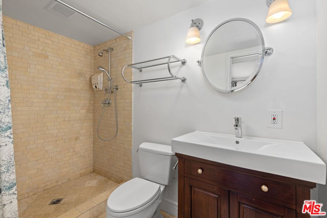 1060 Chantilly Road Los Angeles, CA 90077 - Photo 25 of 40 a bathroom with a sink a toilet and a mirror