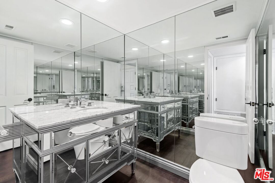 1060 Chantilly Road Los Angeles, CA 90077 - Photo 26 of 40 a bathroom with a sink a toilet a mirror and a shower