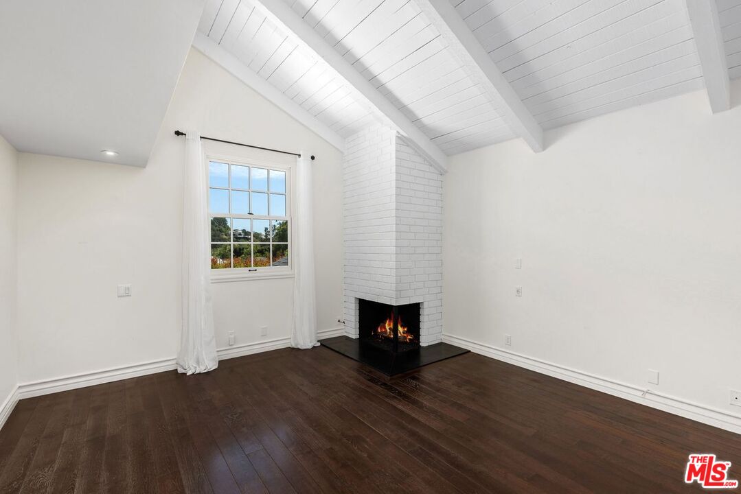1060 Chantilly Road Los Angeles, CA 90077 - Photo 29 of 40 an empty room with wooden floor and windows