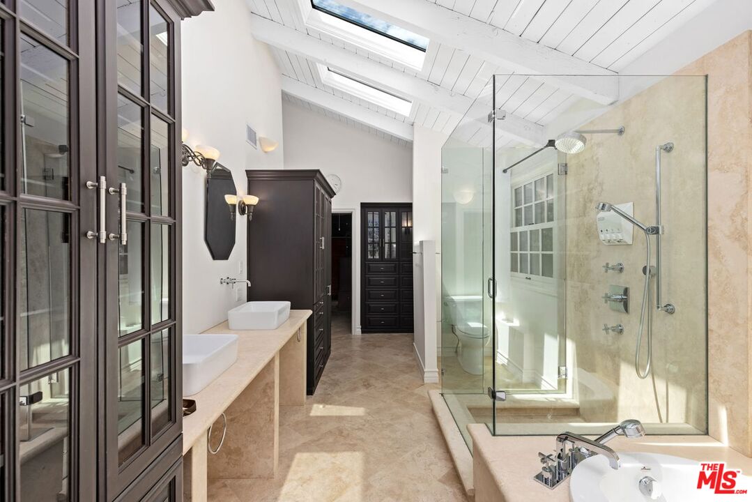 1060 Chantilly Road Los Angeles, CA 90077 - Photo 31 of 40 a bathroom with a tub sink shower and mirror