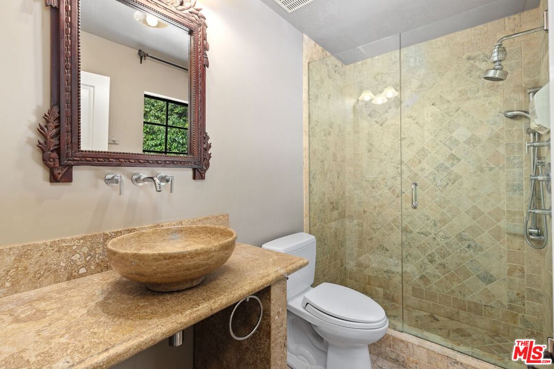 1060 Chantilly Road Los Angeles, CA 90077 - Photo 33 of 40 a bathroom with a granite countertop sink a mirror and a toilet