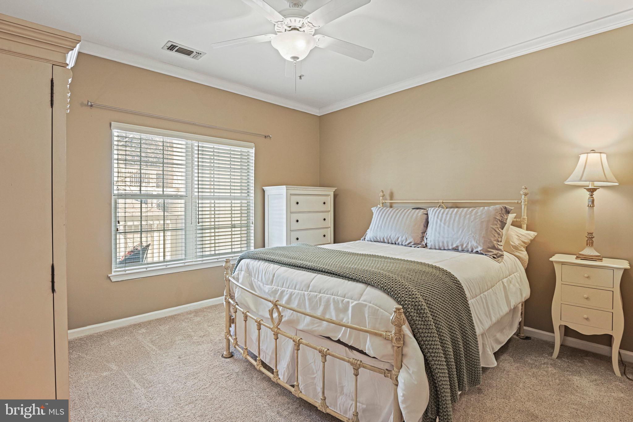 1701 Lake Shore Crest Drive, Unit 24 Reston, VA 20190 - Photo 12 of 33 a bedroom with a bed a chandelier and a window