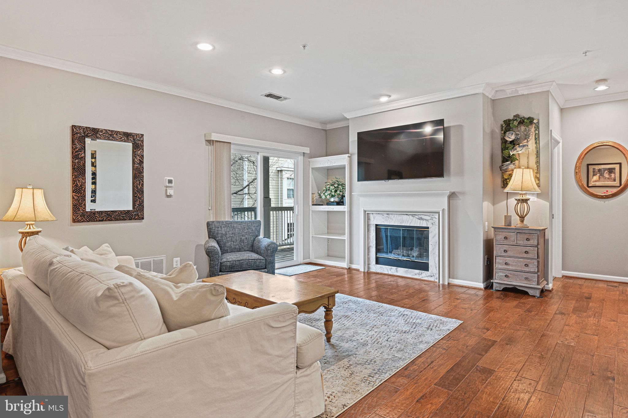 1701 Lake Shore Crest Drive, Unit 24 Reston, VA 20190 - Photo 2 of 43 a living room with furniture a flat screen tv and a fireplace