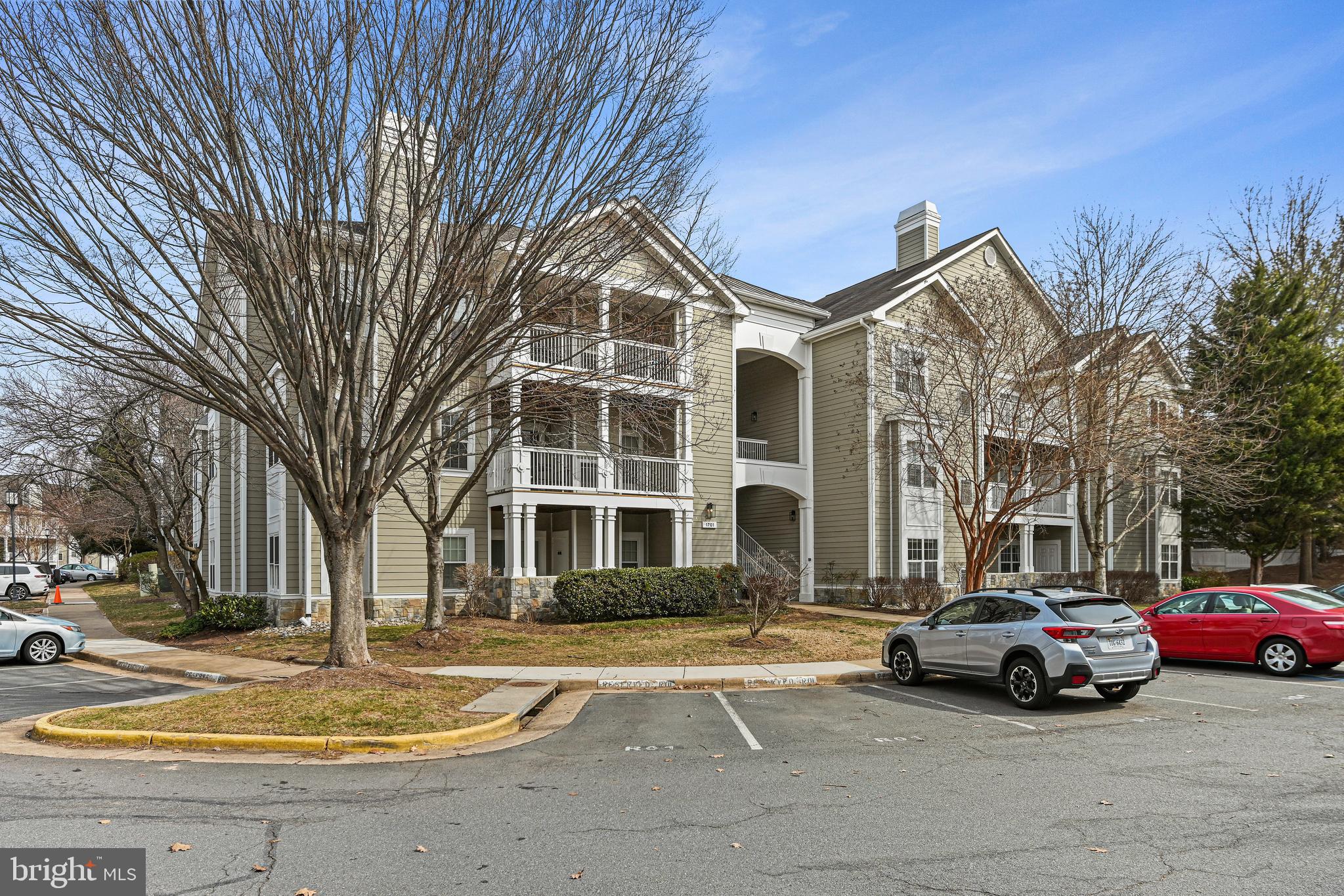 1701 Lake Shore Crest Drive, Unit 24 Reston, VA 20190 - Photo 28 of 43 a front view of a building with lot of cars and trees