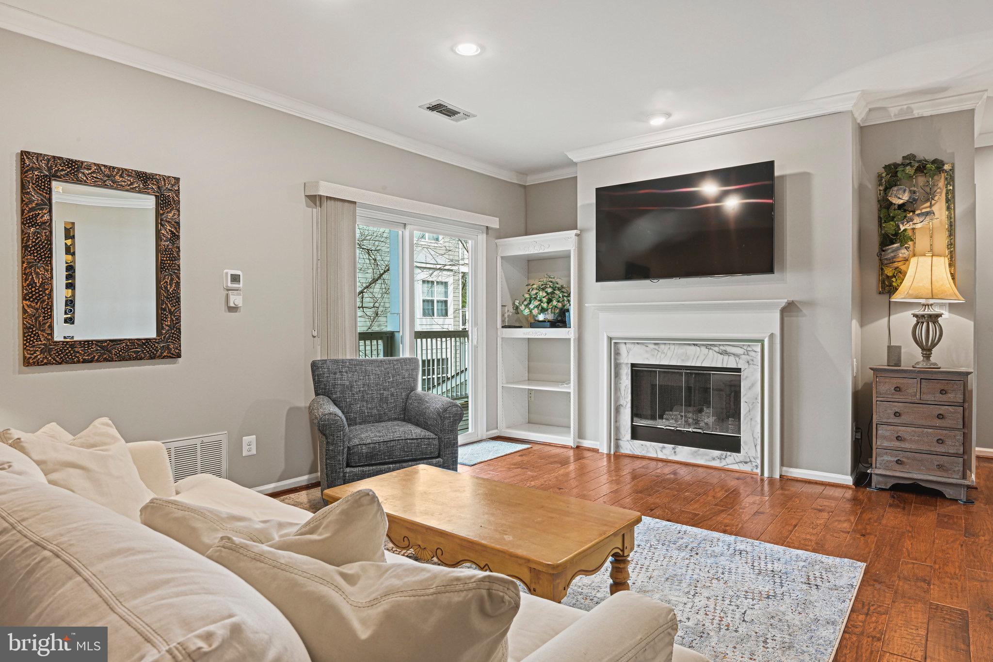 1701 Lake Shore Crest Drive, Unit 24 Reston, VA 20190 - Photo 6 of 43 a living room with furniture flat screen tv and a fireplace