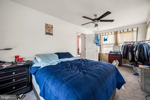 a bedroom with a bed a window and a flat screen tv