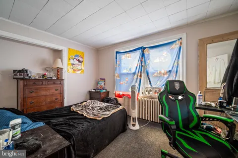 a bedroom with a bed a couch and dresser