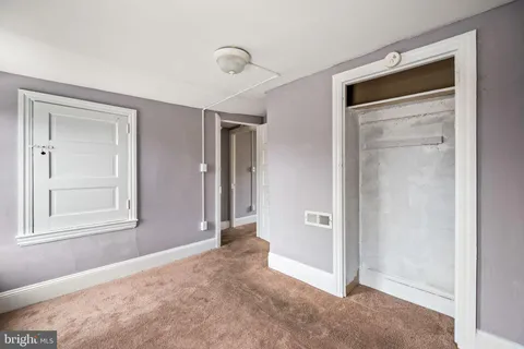an empty room with windows and closet