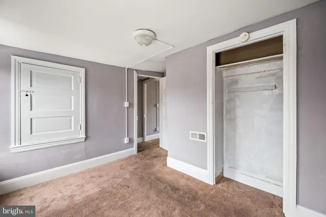 an empty room with windows and closet