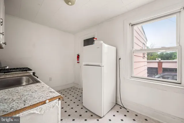 a kitchen with granite countertop a sink stove and cabinets