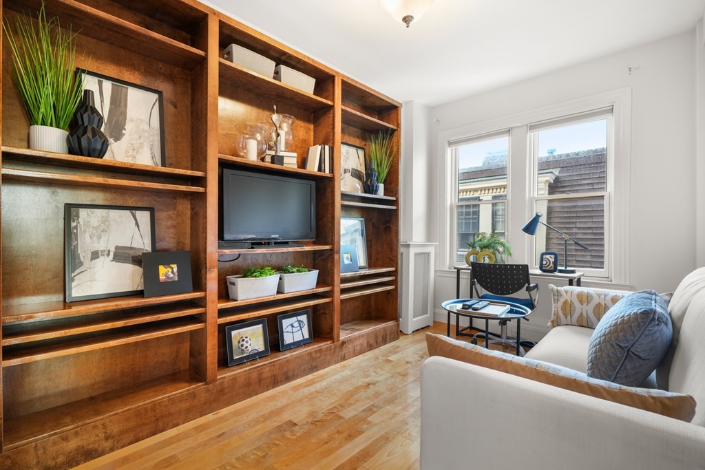 311 Commonwealth Avenue, Unit 41 Boston, MA 02115 - Photo 18 of 31 a living room with furniture a flat screen tv and a floor to ceiling window