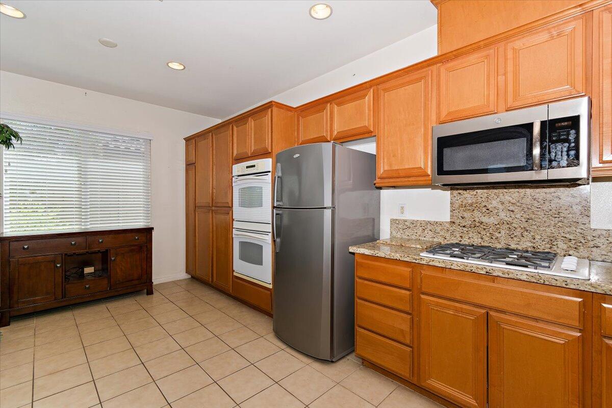 49528 Pacino Street Indio, CA 92201 - Photo 10 of 22 a kitchen with stainless steel appliances granite countertop a refrigerator and a stove top oven