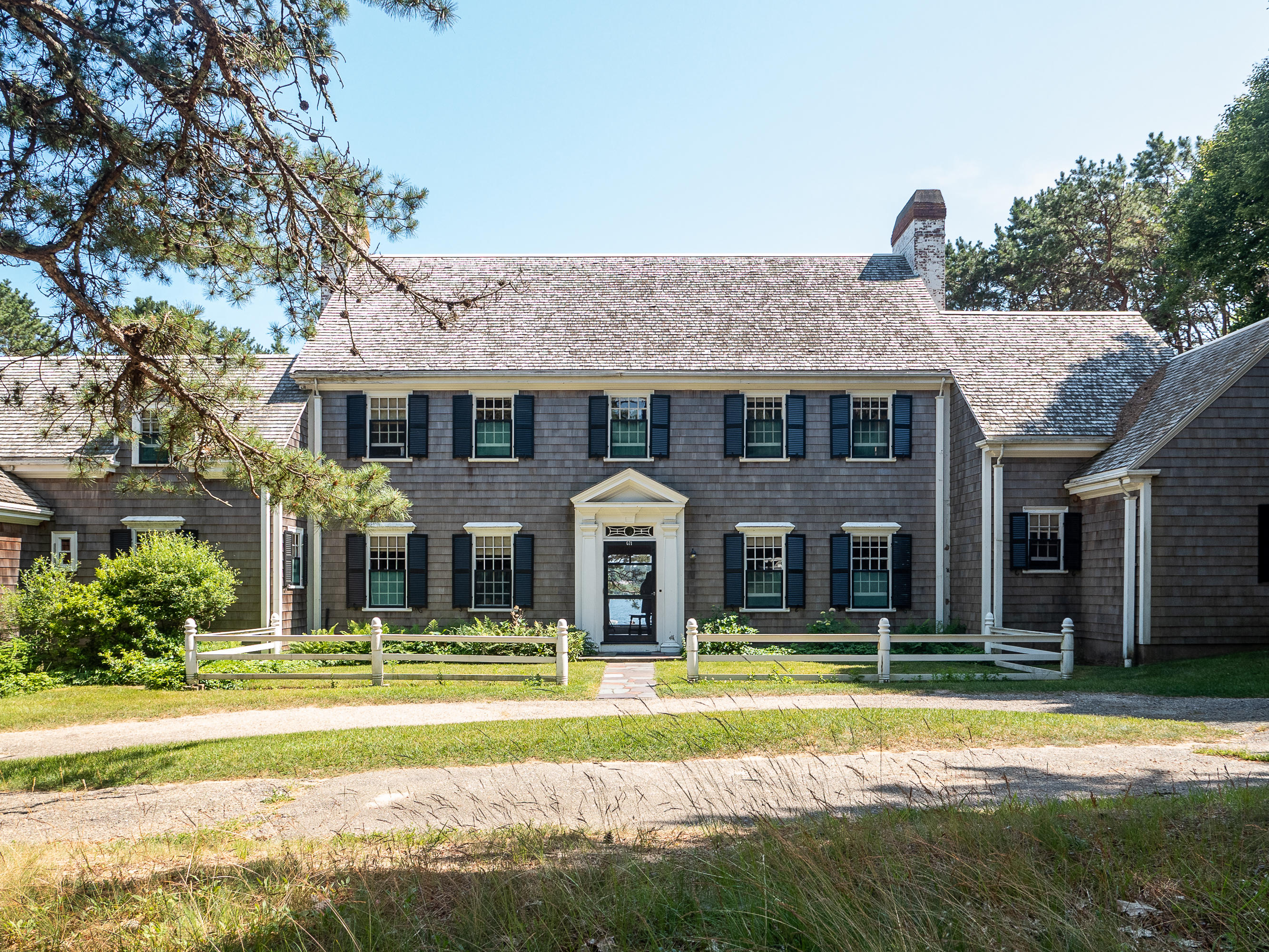 671 Old Post Road Cotuit, MA 02635 - Photo 4 of 36 a front view of a house with a yard table and chairs