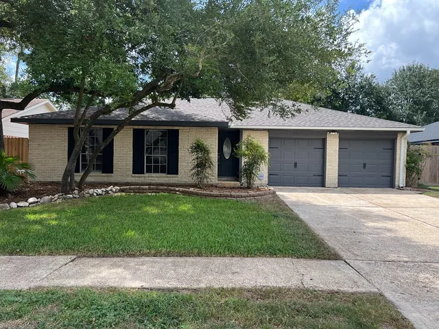 a view of a house with a yard and large tree