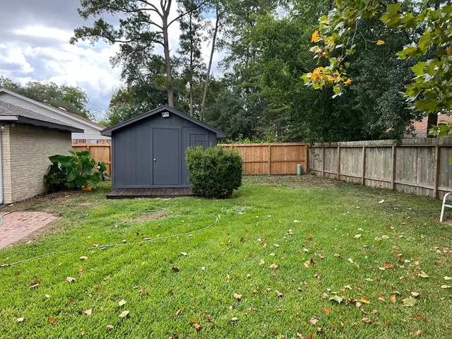 a view of a backyard with potted plants and wooden fence