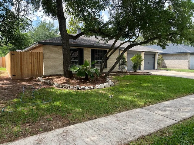 a view of a house with backyard and a tree