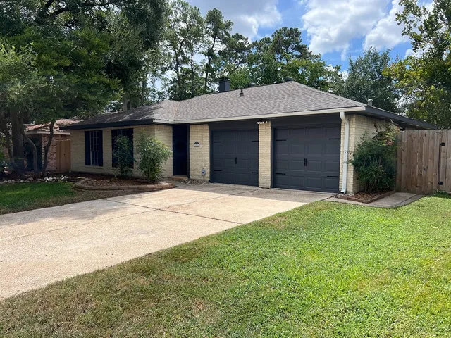 a front view of a house with yard and trees