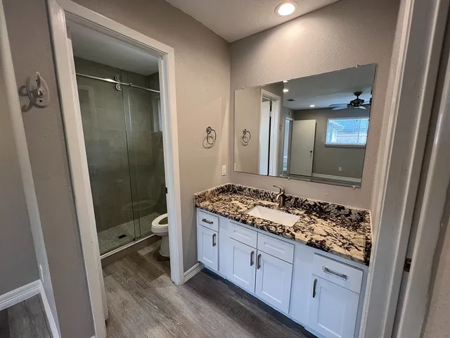 a bathroom with a granite countertop sink and a mirror