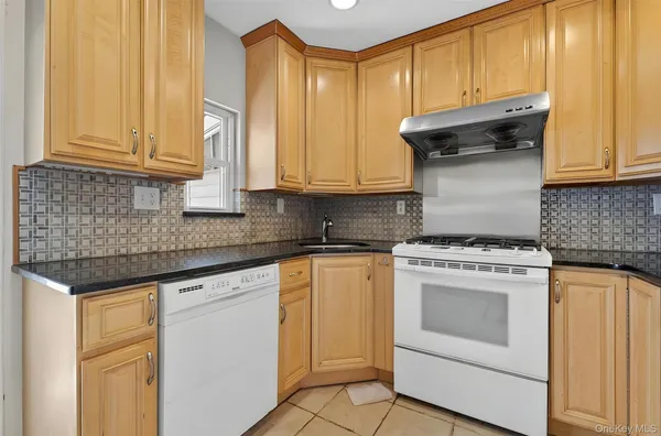 a kitchen with granite countertop cabinets stainless steel appliances granite counter tops and a window