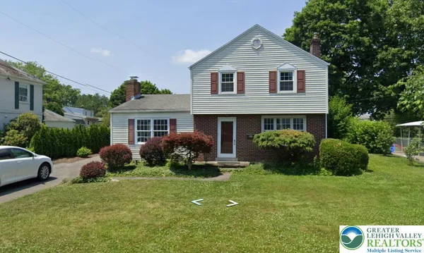 a front view of house with yard and green space