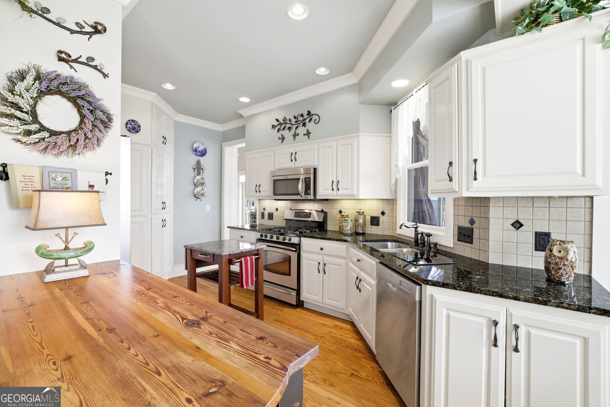 1171 Rabun Bluffs Drive Lakemont, GA 30552 - Photo 14 of 75 a kitchen with stainless steel appliances granite countertop a stove a sink dishwasher and white cabinets with wooden floor