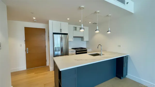 a kitchen with a sink a counter top space stainless steel appliances and cabinets