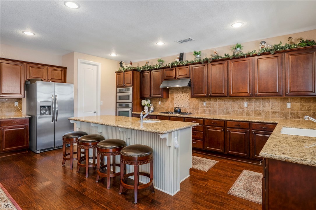 9910 Copenhagen Way Reno, NV 89521 - Photo 9 of 22 a kitchen with stainless steel appliances granite countertop a table chairs sink refrigerator and microwave