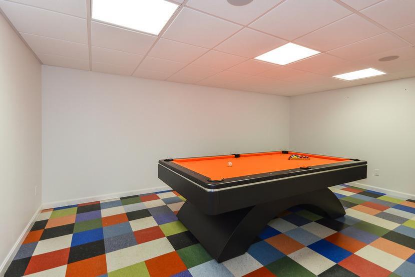 113 James Circle Mashpee, MA 02649 - Photo 19 of 29 a room with a black white checkered floor with a gaming machine and wooden floor