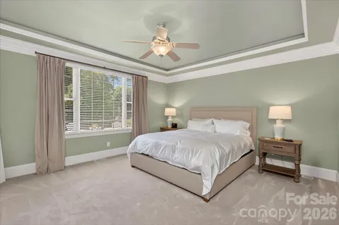 a spacious bedroom with a bed and a chandelier