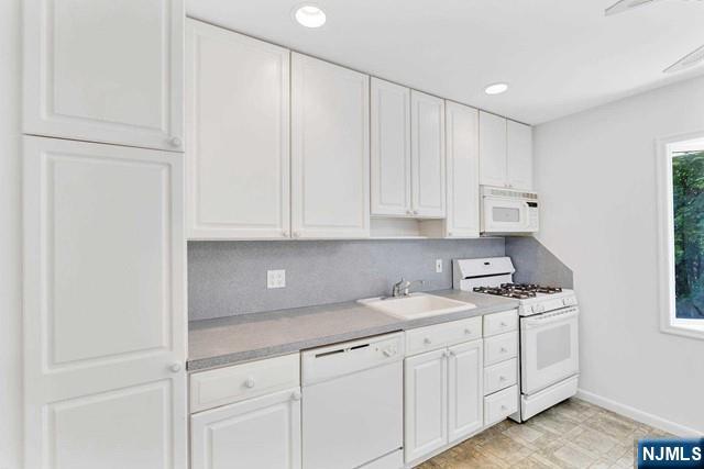 516 Knickerbocker Road Cresskill, NJ 07626 - Photo 7 of 31 a kitchen with white cabinets and white appliances