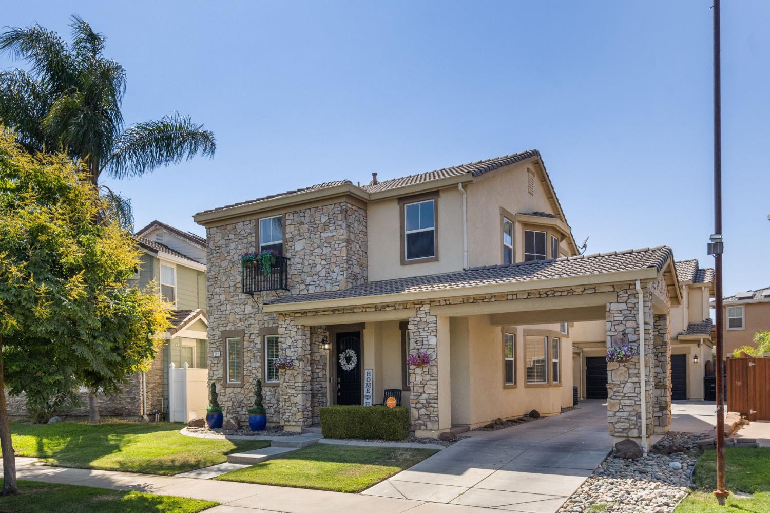 562 Ranger Street Oakdale, CA 95361 - Photo 2 of 63 view of front of property featuring stucco siding, stone siding, concrete driveway, and a tiled roof