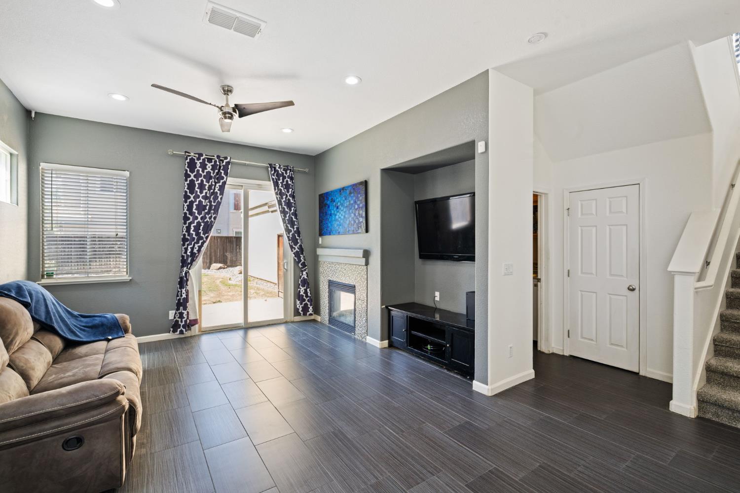 562 Ranger Street Oakdale, CA 95361 - Photo 22 of 63 Family room featuring stairway, a ceiling fan, gas log fireplace, tile flooring, and recessed lighting