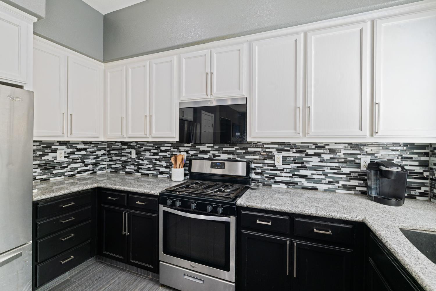 562 Ranger Street Oakdale, CA 95361 - Photo 27 of 63 kitchen with stainless steel appliances, decorative backsplash, and granite countertops