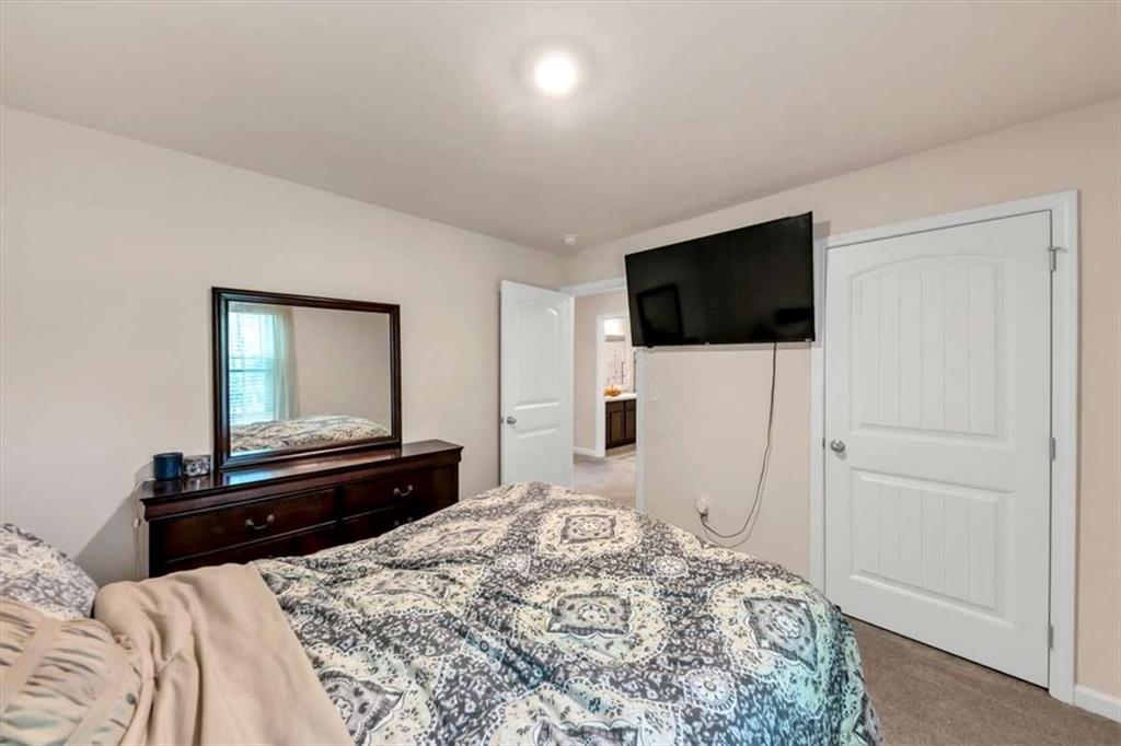 3737 Makeover Court Atlanta, GA 30349 - Photo 21 of 34 a bedroom with a bed and a flat screen tv