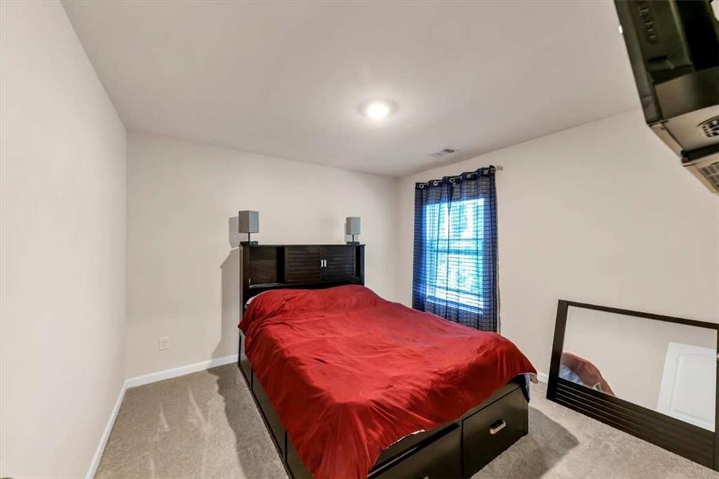 3737 Makeover Court Atlanta, GA 30349 - Photo 22 of 34 a bed sitting in a bedroom next to a window