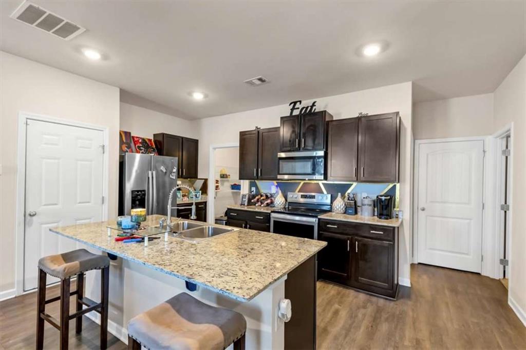 3737 Makeover Court Atlanta, GA 30349 - Photo 8 of 34 a kitchen with kitchen island a sink stove and refrigerator