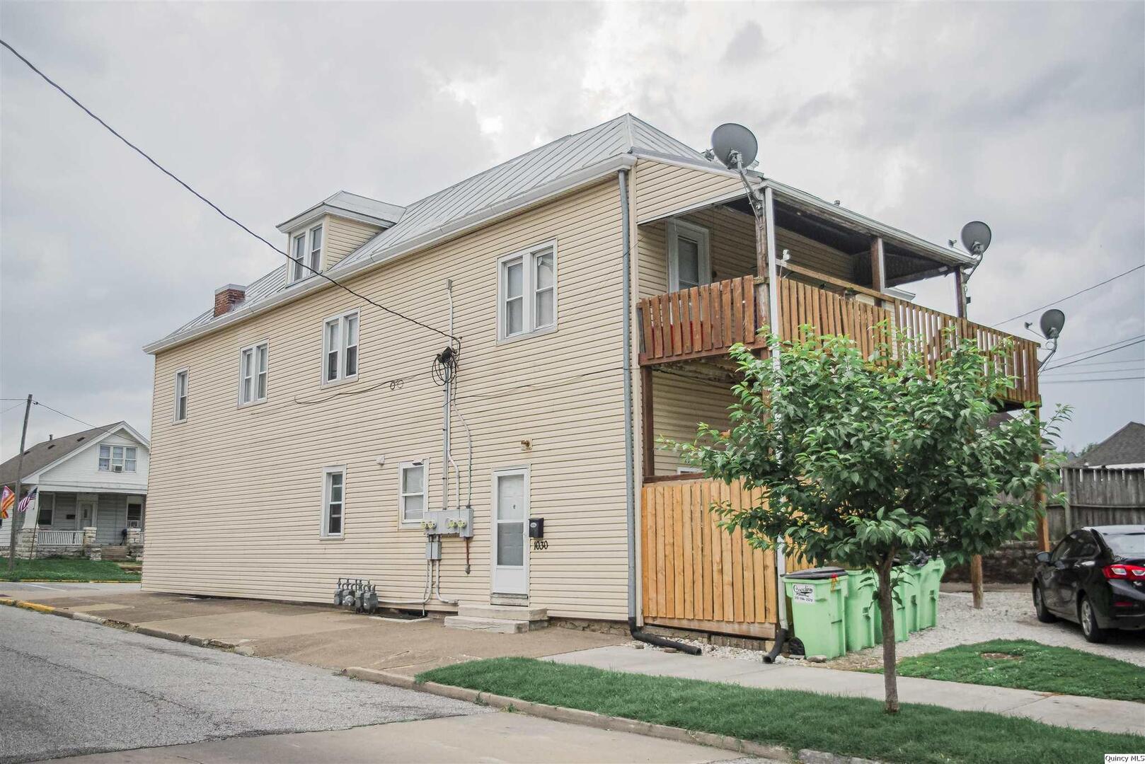 727-729 Monroe Street Quincy, IL 62301 - Photo 2 of 7 a front view of a house with a yard and garage