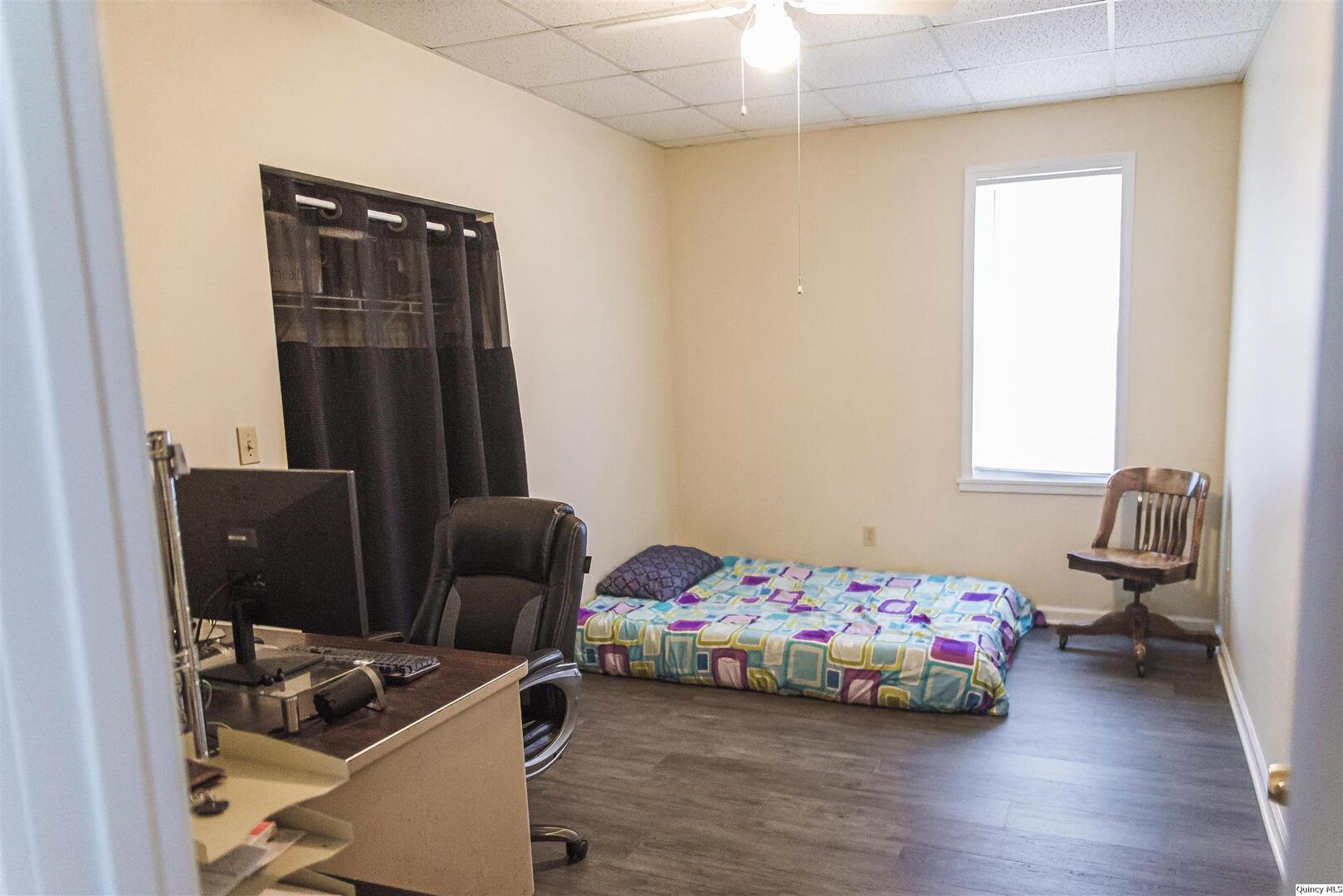 727-729 Monroe Street Quincy, IL 62301 - Photo 5 of 7 a bedroom with a bed and wooden floor