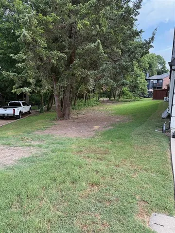a view of a field with large trees