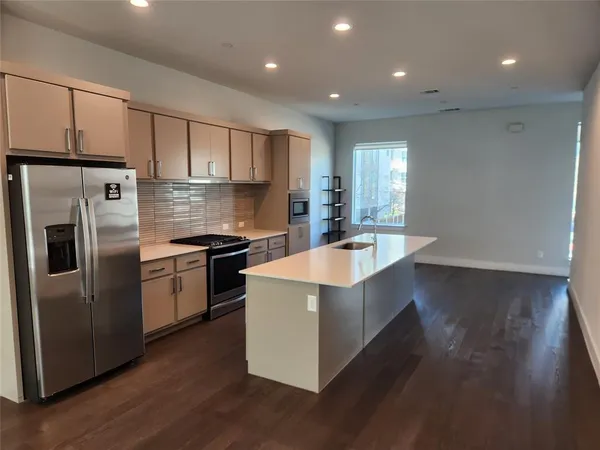 a kitchen with stainless steel appliances a sink a stove a refrigerator and cabinets