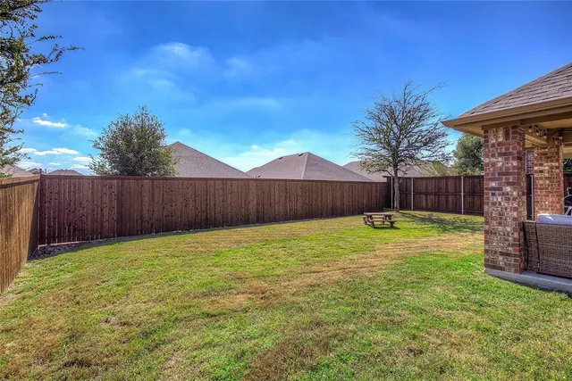 a view of a house with backyard and sitting area