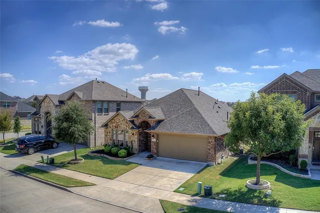 an aerial view of a house with a garden and lake view