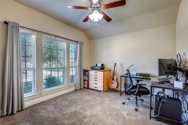 a view of a workspace with furniture and a window