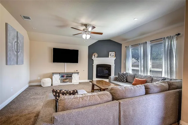 a living room with furniture a fireplace and a flat screen tv