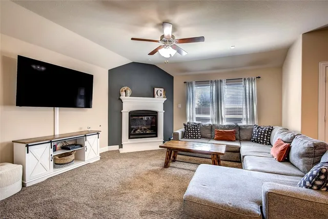 a living room with furniture a flat screen tv and a fireplace