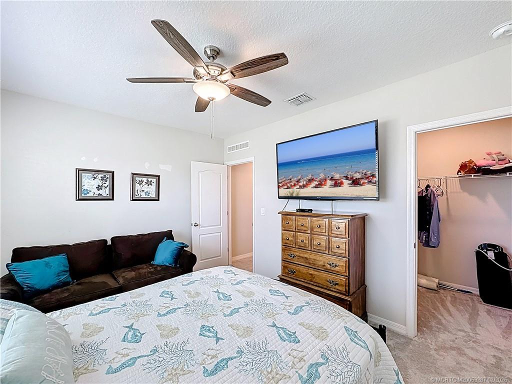 4341 Southwest Appleseed Road Port St. Lucie, FL 34953 - Photo 11 of 25 a bedroom with a large bed and a chandelier