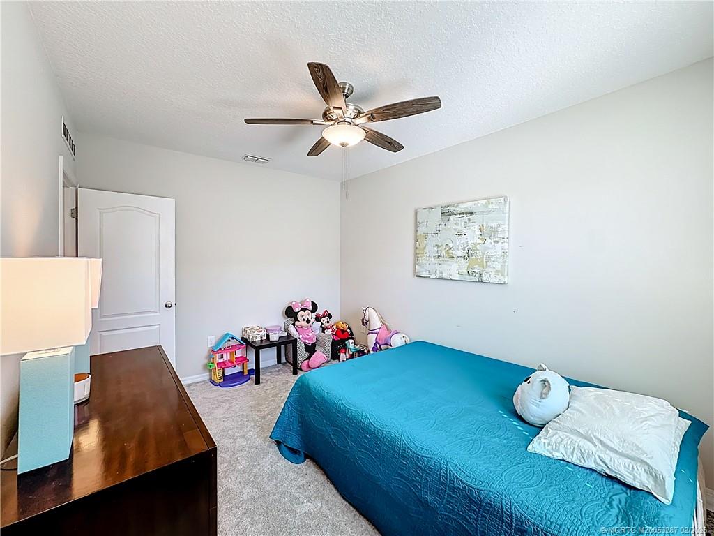 4341 Southwest Appleseed Road Port St. Lucie, FL 34953 - Photo 12 of 25 a bedroom with furniture and a window