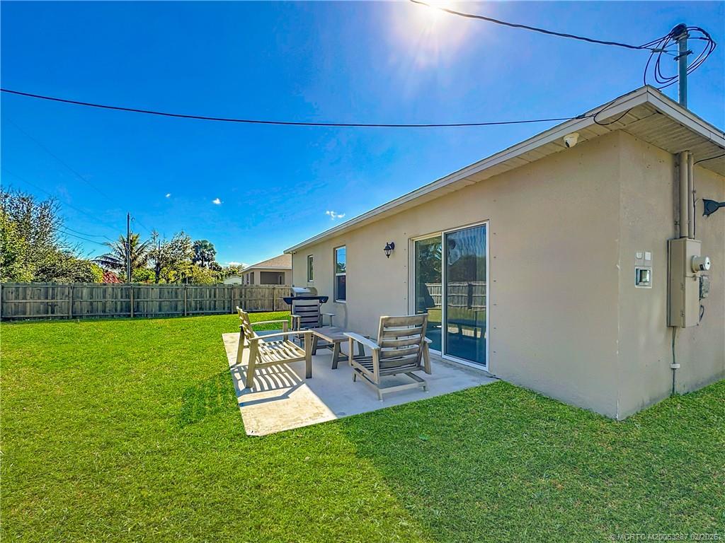 4341 Southwest Appleseed Road Port St. Lucie, FL 34953 - Photo 15 of 25 a view of a patio with table and chairs potted plants and floor to ceiling window