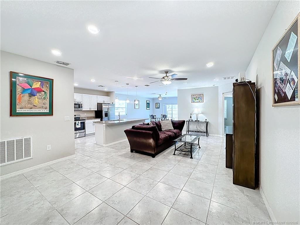 4341 Southwest Appleseed Road Port St. Lucie, FL 34953 - Photo 21 of 25 a living room with furniture and a refrigerator