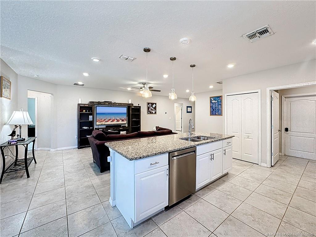 4341 Southwest Appleseed Road Port St. Lucie, FL 34953 - Photo 4 of 25 a kitchen with stainless steel appliances granite countertop a sink and a stove